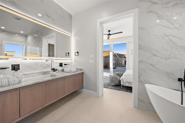 full bathroom with double vanity, visible vents, a soaking tub, ceiling fan, and recessed lighting