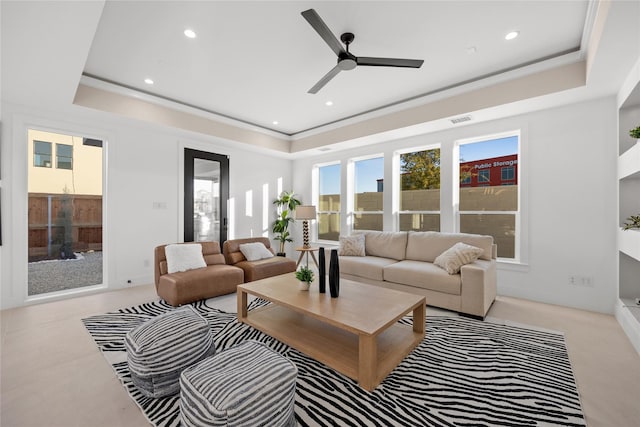 living area with recessed lighting, a raised ceiling, and visible vents