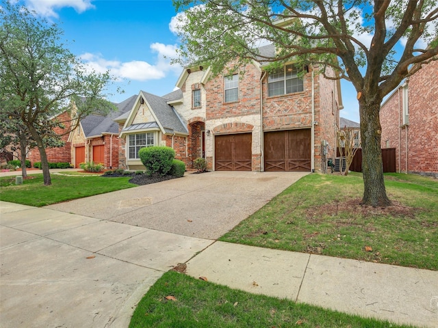 traditional home with driveway, a shingled roof, an attached garage, a front lawn, and brick siding