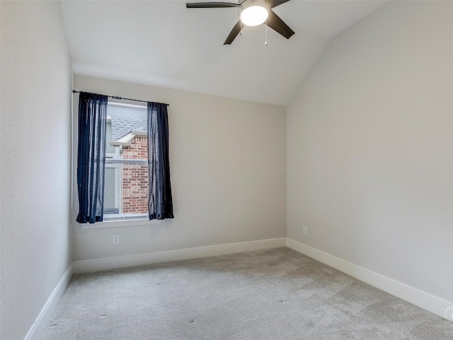 unfurnished room featuring a ceiling fan, carpet, vaulted ceiling, and baseboards