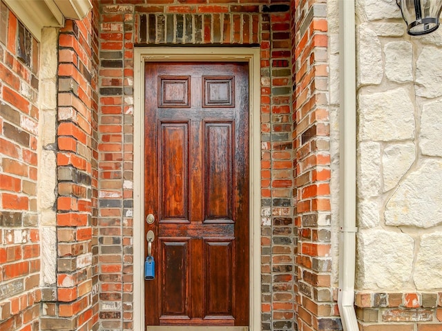 view of exterior entry with brick siding