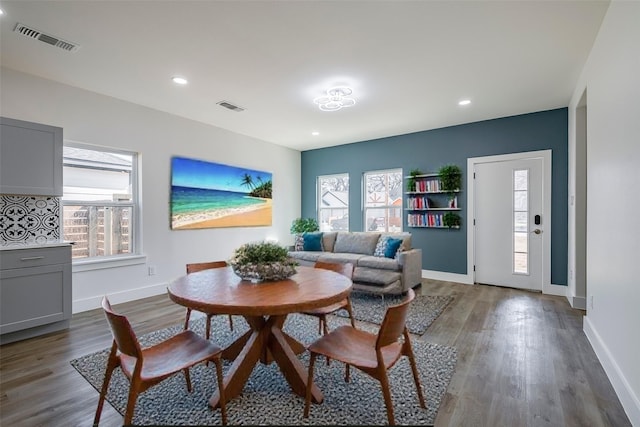 dining space featuring baseboards, visible vents, wood finished floors, and recessed lighting