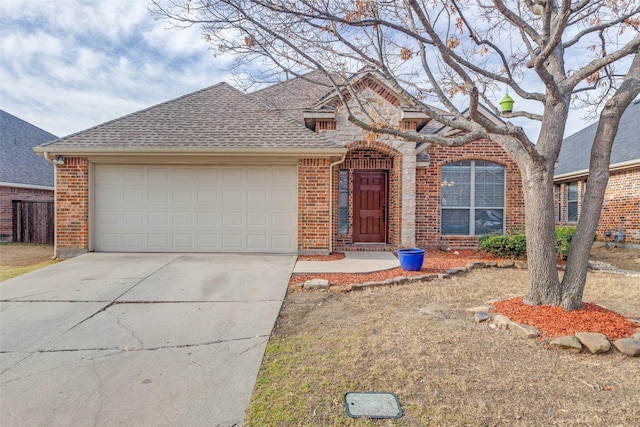 view of front of property with a garage, driveway, a shingled roof, and brick siding