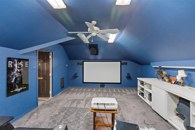 carpeted home theater featuring baseboards, ceiling fan, lofted ceiling, and visible vents