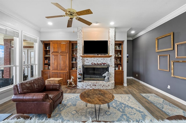 living room with a ceiling fan, a brick fireplace, and wood finished floors