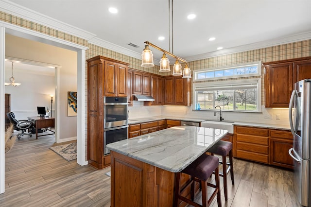 kitchen featuring a sink, ornamental molding, stainless steel appliances, and visible vents