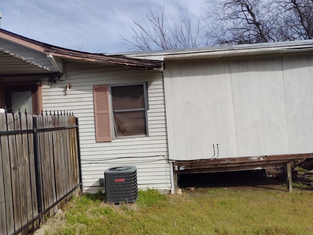 view of side of property featuring central AC unit and fence