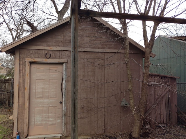 view of outbuilding featuring fence and an outdoor structure