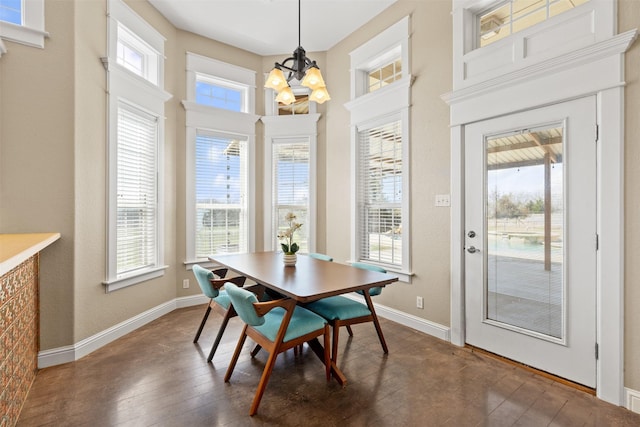 dining area with a chandelier, dark wood-style flooring, and baseboards