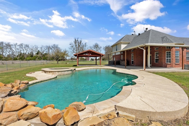 view of pool featuring fence, a pool with connected hot tub, a gazebo, a lawn, and a patio area