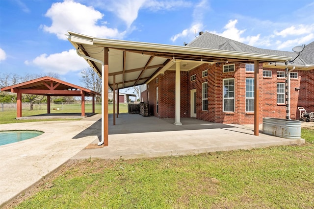 view of patio / terrace with an outdoor pool, an attached carport, and a gazebo