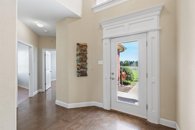 foyer with baseboards and hardwood / wood-style floors