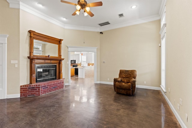 sitting room with a brick fireplace, visible vents, ornamental molding, and a ceiling fan