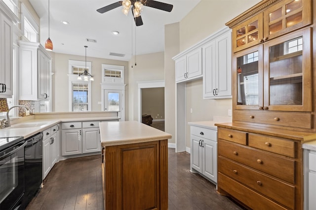 kitchen featuring dishwasher, a sink, glass insert cabinets, and white cabinetry