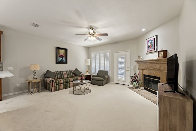 living room with ceiling fan, a fireplace, carpet flooring, visible vents, and baseboards