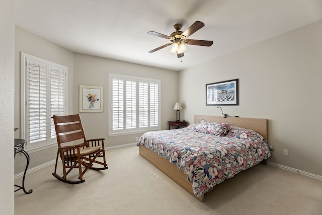 carpeted bedroom with ceiling fan and baseboards