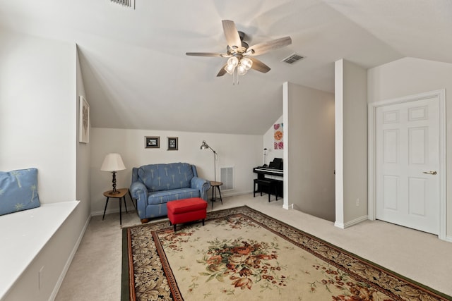 interior space featuring light carpet, visible vents, vaulted ceiling, and a ceiling fan