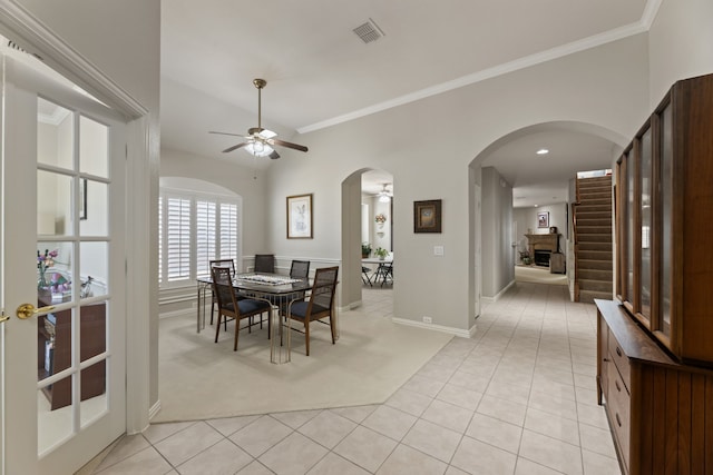 dining room with ornamental molding, arched walkways, visible vents, and light tile patterned floors