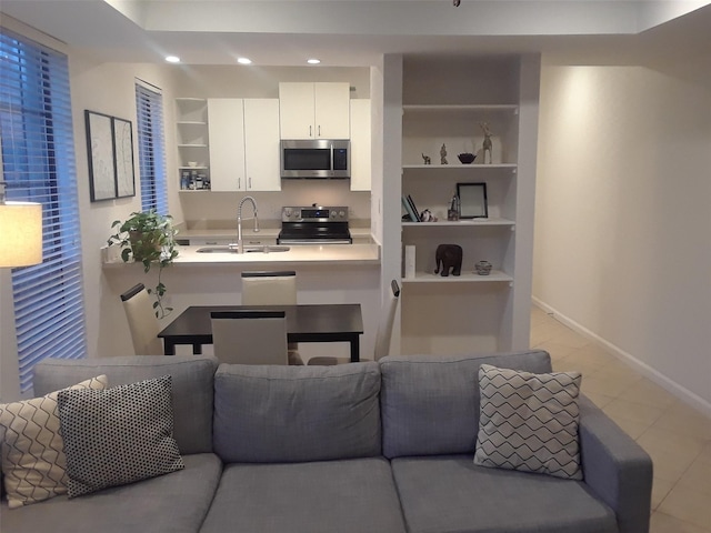 kitchen featuring open shelves, stainless steel appliances, light countertops, white cabinets, and a sink