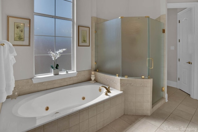 bathroom featuring plenty of natural light, a jetted tub, tile patterned flooring, and a shower stall