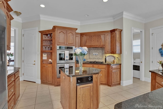 kitchen featuring light tile patterned floors, ornamental molding, stainless steel appliances, and dark stone counters