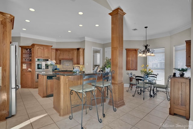 kitchen with ornate columns, light tile patterned floors, a kitchen bar, and stainless steel appliances