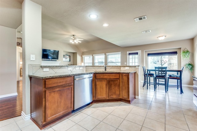 kitchen featuring visible vents, brown cabinetry, dishwasher, and light tile patterned flooring