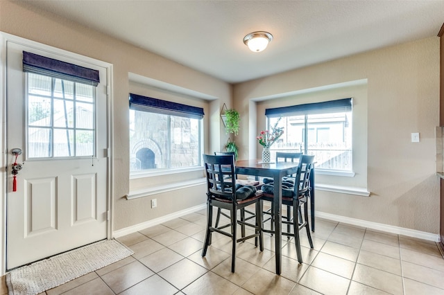 dining space with light tile patterned floors and baseboards