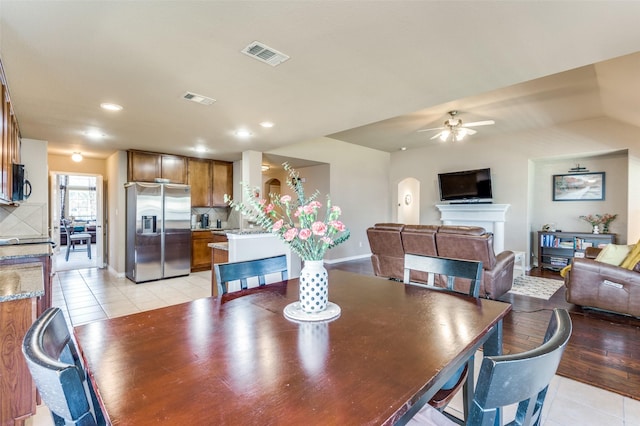 dining space featuring visible vents, a fireplace, and light tile patterned flooring