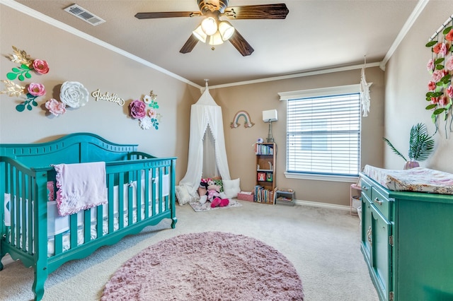 bedroom with a nursery area, carpet, visible vents, and crown molding