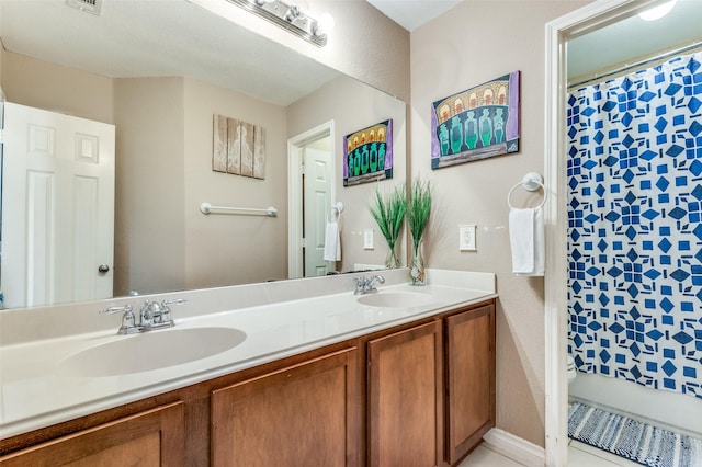 bathroom featuring double vanity, curtained shower, and a sink