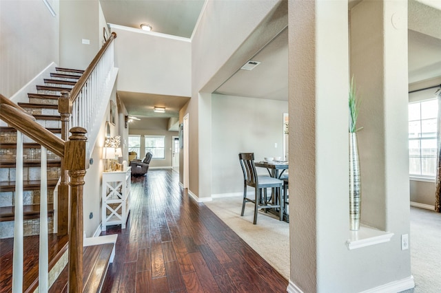 foyer with stairs, hardwood / wood-style floors, visible vents, and baseboards