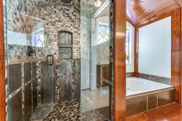 bathroom with lofted ceiling, a stall shower, and a garden tub