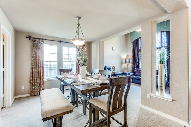 dining area with light carpet and baseboards