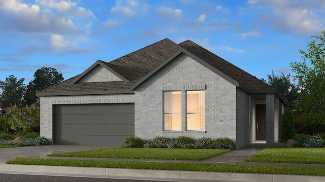 view of front of home with an attached garage, a yard, driveway, and brick siding