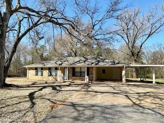 view of front facade featuring a carport, brick siding, and driveway