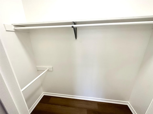 walk in closet with wood finished floors