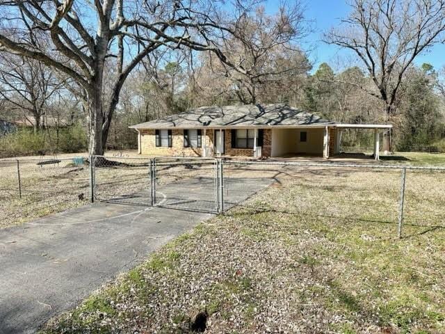 ranch-style home featuring a carport, brick siding, fence, and a gate