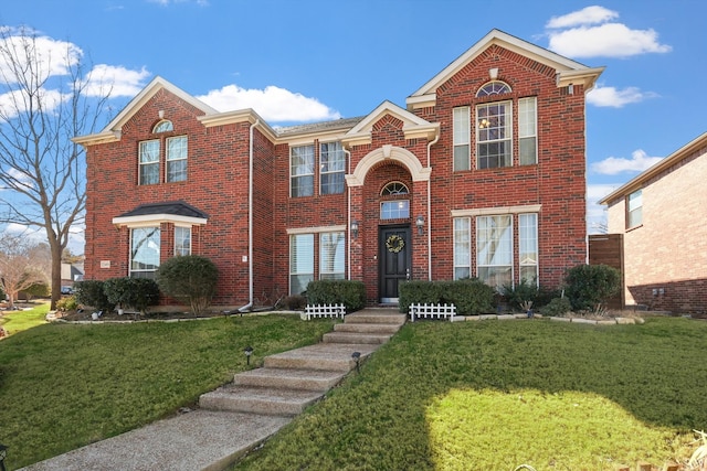 traditional-style house featuring a front lawn and brick siding