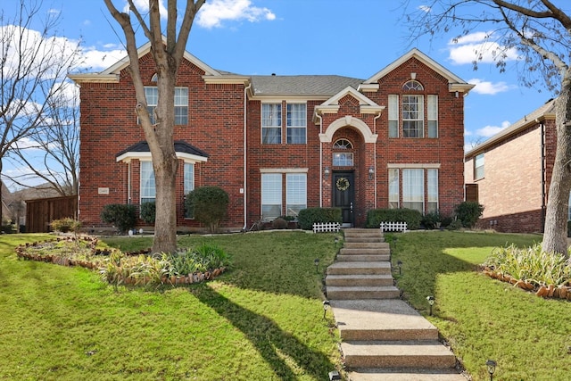 traditional-style house featuring brick siding and a front yard