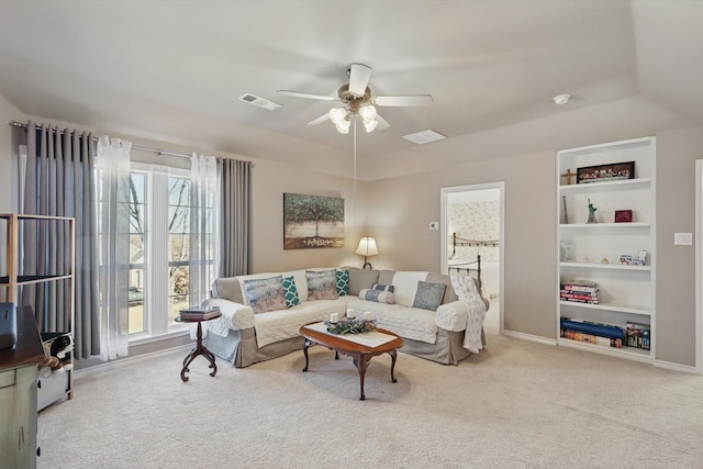 living room with ceiling fan, built in shelves, visible vents, baseboards, and carpet