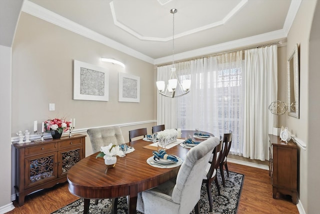 dining area featuring baseboards, ornamental molding, a chandelier, and wood finished floors