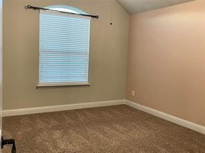 carpeted spare room with lofted ceiling and baseboards