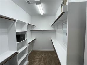 walk in closet featuring dark colored carpet and visible vents