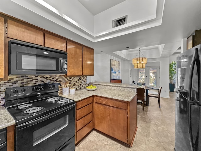 kitchen featuring visible vents, a raised ceiling, a peninsula, black appliances, and backsplash