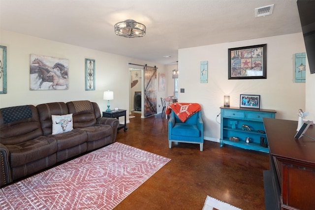 living room featuring a barn door, finished concrete flooring, visible vents, and baseboards