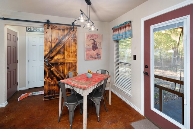 dining space featuring finished concrete flooring, a barn door, and baseboards