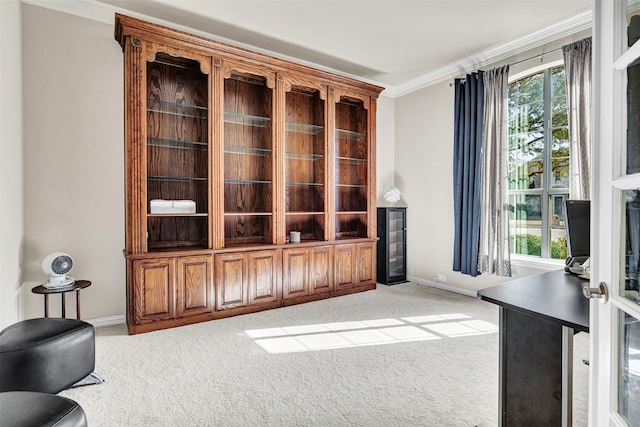 living area with a healthy amount of sunlight, baseboards, ornamental molding, and light colored carpet