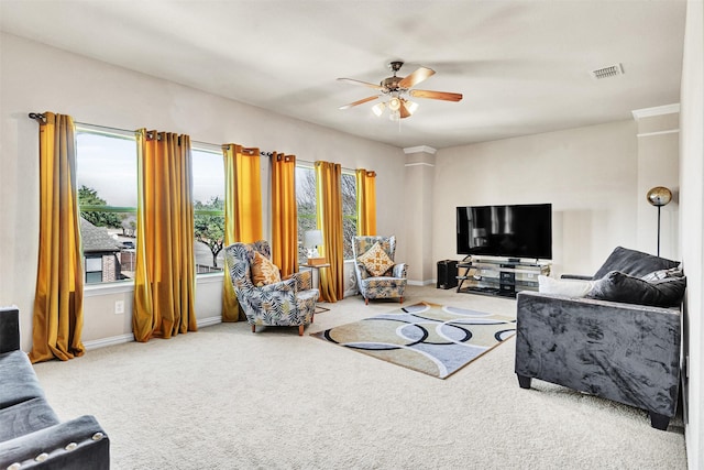 living area featuring baseboards, carpet, visible vents, and a ceiling fan