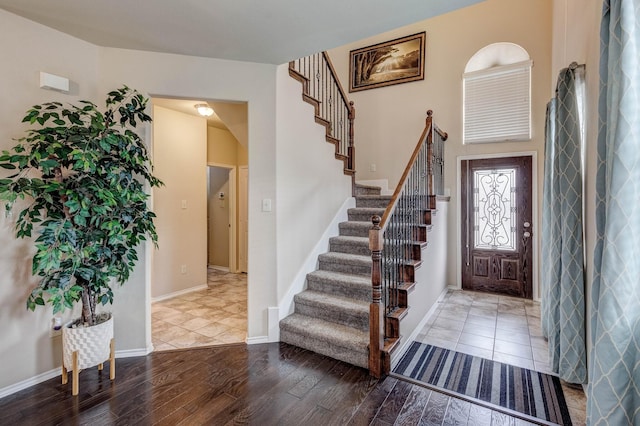 foyer featuring stairway, wood finished floors, and baseboards